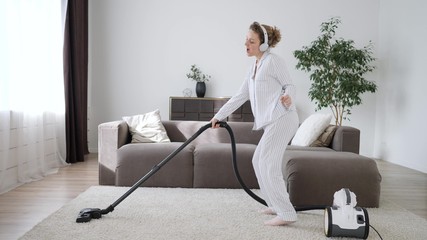 Happy Female Dancing With Vacuum Cleaner At Home.