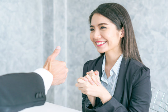 Asian business woman employee with smiling face for her success good job compliments from her boss and given a thumbs up  - business success concept