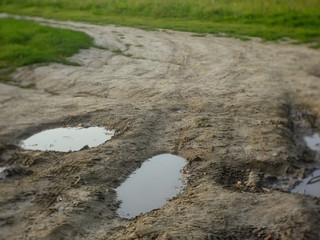 dirt road with puddles in summer, Russia