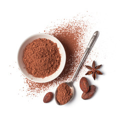 Cocoa powder and beans in white bowl with silver spoon