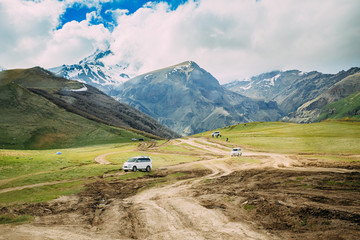 Tourist Cars SUV Go On Off Road With Views Of Mount Kazbek Near Village Of Gergeti In Georgia © Great Brut Here
