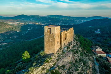 Aerial view of ancient ruined Gothic Beselga castle above the Peniscola Morella road with half restored keep tower and palace building supported by steel beams during sunset