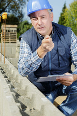 man engineer with clipboard while looking at camera