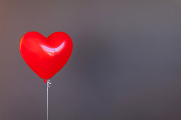 Fototapeta na wymiar Red balloon heart shape on gray backround