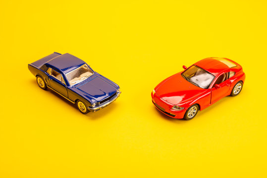 Two Toy Cars On A Yellow Background