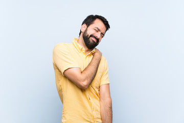 Naklejka premium Young man with beard over isolated blue background suffering from pain in shoulder for having made an effort