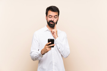 Young man with beard holding a mobile Looking front