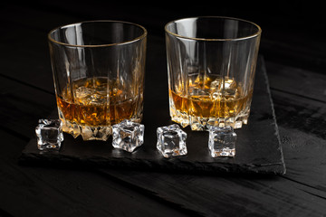 glass of whiskey and ice on wooden table