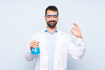 Young scientific holding laboratory flask over isolated background in zen pose