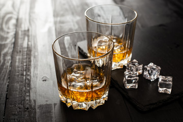 glass of whiskey and ice on wooden table