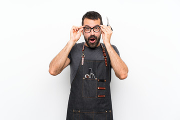 Barber man in an apron with glasses and surprised