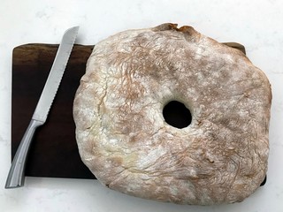 A close up of a loaf of a large Ciabatta bread in the form of a wheel