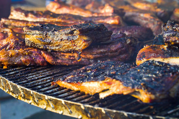 Crusty grilled pork ribs on metal lattice at barbecue party