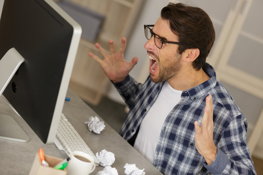 screaming angry man sitting in office