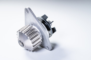 New metal automobile pump for cooling the engine of a water pump on a gray background. The concept of new spare parts for the car engine