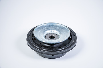 New thrust bearing of front suspension strut of a car on a gray background. The concept of new spare parts and replacement parts in service centers