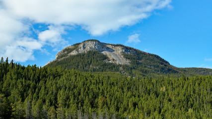 Mountain near Banff national park with trees, clouds and blue sky