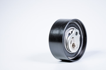 Tension roller of a timing belt of an internal combustion engine on a gray background. The concept of new spare parts and maintenance of vehicles