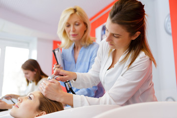 future hairdresser wetting clients hair