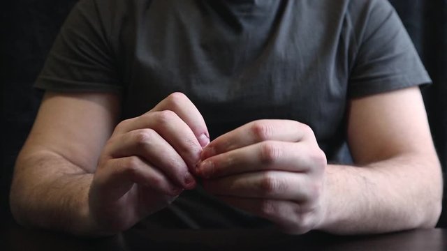 Close view of male hands with strongly bitten nails. Finger selection with alarm. Ugly bitten fingers, cuticles, wounds on the fingers. Bad habit. The concept of onychophagy and dermatophagy.