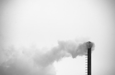 emissions from factory chimney smokestack. winter