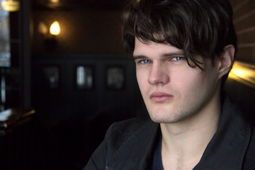 Portrait brunet guy in jacket, close-up. Serious