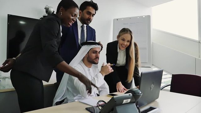 Mixed business team in Dubai. Business meeting with men wearing kandura and western people in the office