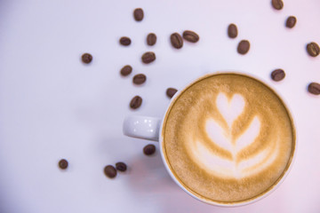 coffee with heart pattern on foam and coffee beans