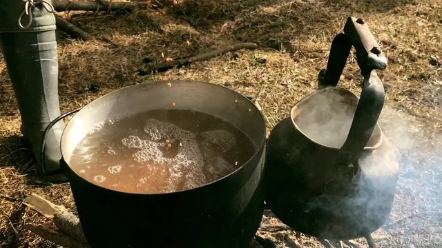 Outdoor cooking - bonfire and boiling pot, steam and smoke