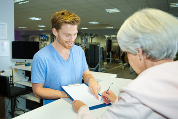 elderly lady signing in at fitness center