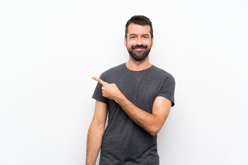 Young handsome man over isolated white background pointing to the side to present a product