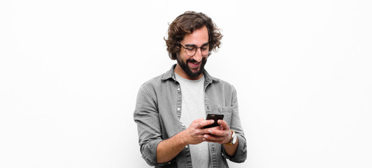 young crazy cool man using his smartphone against white wall