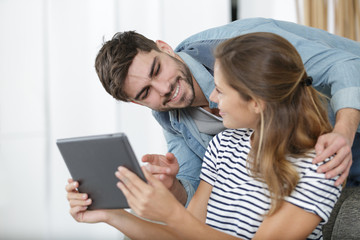 sweet couple is watching content online on tablet