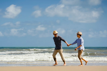 Fototapeta na wymiar Asian senior couple elder retire resting relax walking at sunrise beach honeymoon.Happy family together people lifestyle