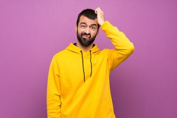 Handsome man with yellow sweatshirt with an expression of frustration and not understanding