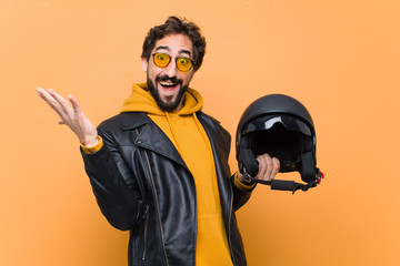 young crazy cool man rider, holding a motorbike helmet.