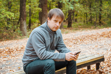 man is talking on the phone in autumn forest