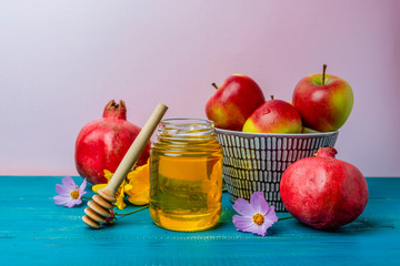 Jar of honey, apples and pomegranates on the table for the holiday of Rosh Hashanah