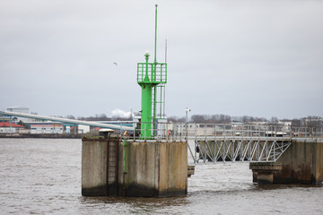 Small green ship dock lighthouse in Baltic Sea.