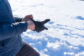 Woman putting winter sport glove in hand, getting ready for extreme cold weather and adventure...