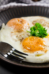 Fried eggs and bread for breakfast on a gray background.