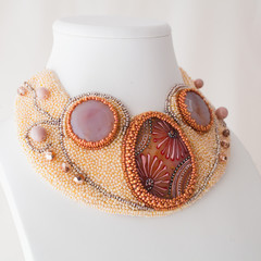 colored handmade jewelry made of beads, stones and metal on a white background