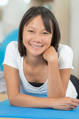 Fototapeta na wymiar smiling woman after doing splits on mat at home