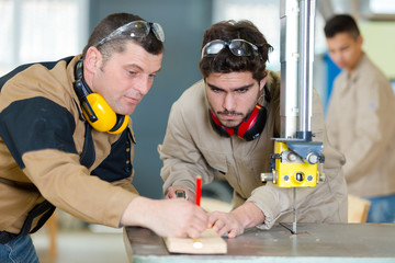 two carpenters are talking while working
