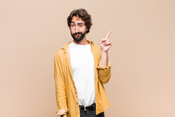 young crazy cool man feeling like a genius holding finger proudly up in the air after realizing a...