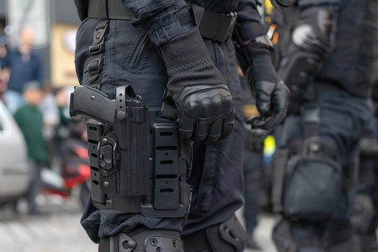 Close-up view to armed police officer with gun