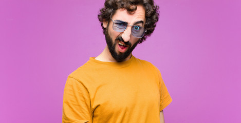 young crazy cool man looking shocked, angry, annoyed or disappointed, open mouthed and furious...