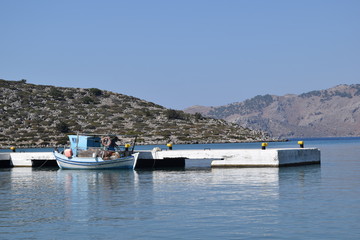Fototapeta na wymiar A small fishing boat on the shore of the Greek island of Simi.