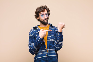 young crazy cool man looking impatient and angry, pointing at watch, asking for punctuality, wants...