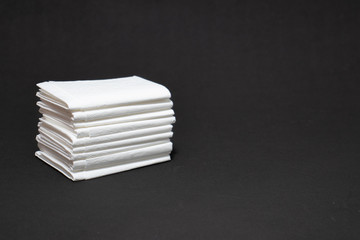 White paper tissues on dark black background.